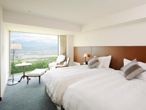 Habitación de hotel con cama grande y ventana grande. en Furano Resort Orika, en Nakafurano