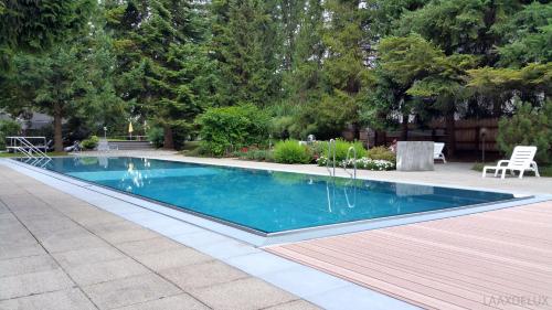 a swimming pool with blue water in a yard at Rancho Laaxdeluxe in Laax