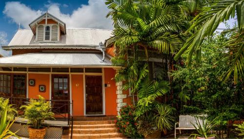 una casa de naranjos con una palmera delante de ella en Inn at 87, en Puerto España