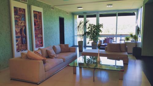 a living room with a couch and a coffee table at Tres Pircas Hotel & Spa in Huerta Grande