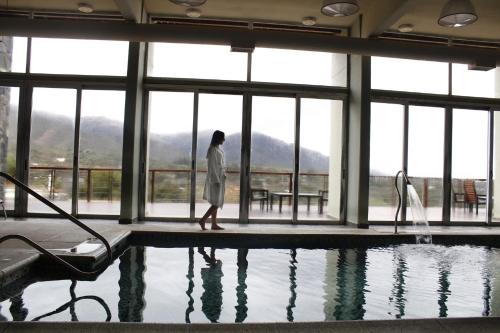 a man standing in front of a swimming pool at Tres Pircas Hotel & Spa in Huerta Grande