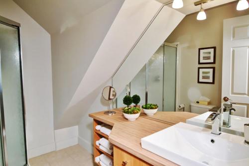 La salle de bains est pourvue d'un lavabo et d'un miroir. dans l'établissement Chalets Alpins - 38 Chemin des Skieurs, à Stoneham