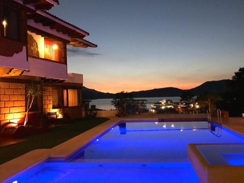 a swimming pool in front of a house at night at Hotel puesta del sol in Valle de Bravo