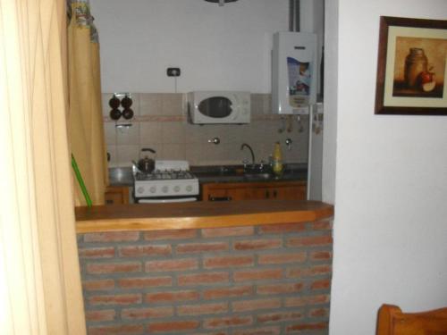 a kitchen with a brick counter top and a stove at Cabañas Los Gauchitos in La Falda