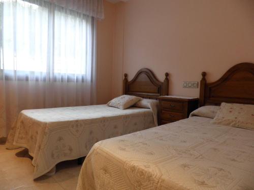 a bedroom with two beds and a window at Milano in Sanxenxo