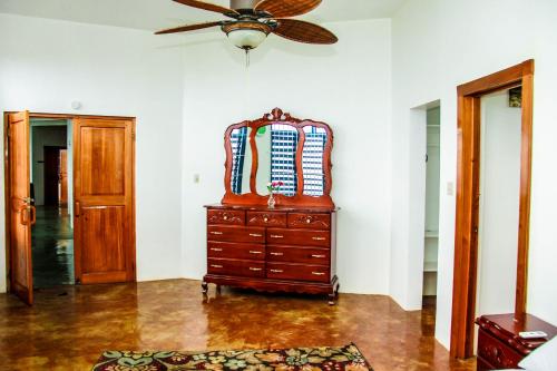 a room with a dresser and a ceiling fan at Sunshine Lodge: Your home away from home in Montego Bay