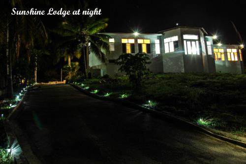 a house with lights on a driveway at night at Sunshine Lodge: Your home away from home in Montego Bay
