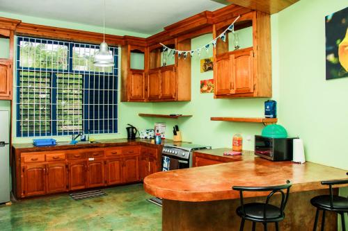 a kitchen with wooden cabinets and a wooden table at Sunshine Lodge: Your home away from home in Montego Bay