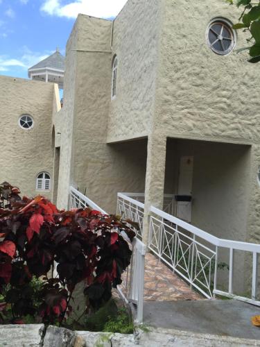 a house with a white fence in front of it at One more night in Ocho Rios