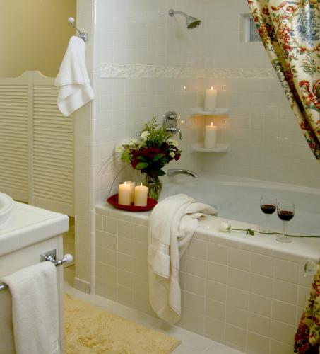 a bathroom with a bath tub with candles and two glasses of wine at Cottage on Armstrong in Lodi