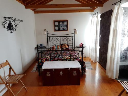 a bedroom with a black bed and a wooden floor at Adega da Figueira in Calheta de Nesquim