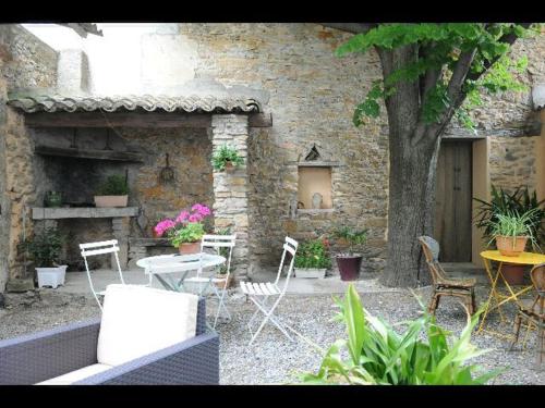a patio with chairs and a table and a tree at Le Sillon d'Alaric in Lézignan-Corbières