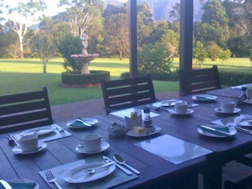a wooden table with plates and utensils on it at Yarrahapinni Homestead in Yarrahapinni