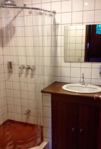 a bathroom with a sink and a shower with a mirror at Arco Iris Lodge in Monteverde Costa Rica