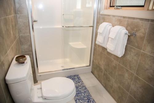 a bathroom with a toilet and a shower with towels at The Sentinel in Kaslo