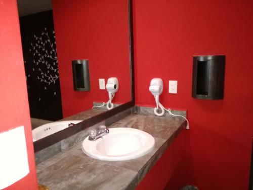 baño con lavabo y pared roja en Privilege, en Coatzacoalcos