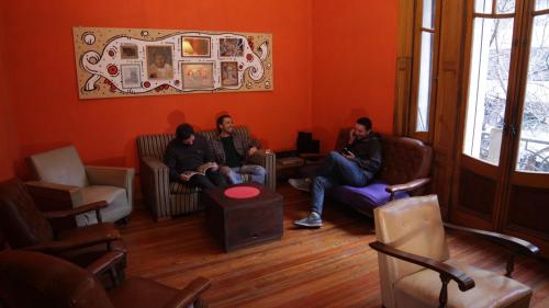two men sitting on couches in a living room at Hostel Brava mansa in Rosario