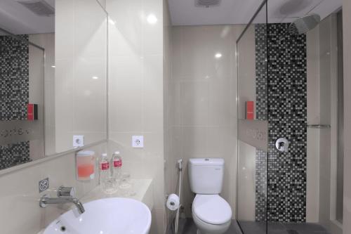 y baño con aseo, lavabo y ducha. en favehotel Bandara Tangerang en Tangerang
