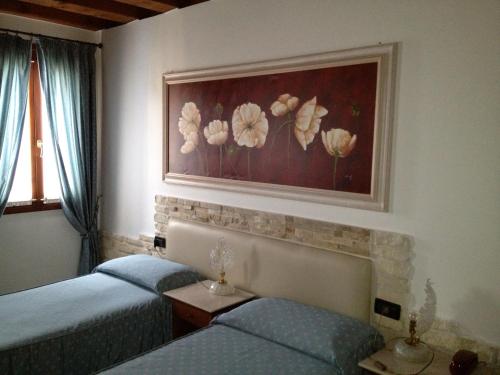 a bedroom with two beds and a painting on the wall at Ca'Nova Alloggi in Campalto