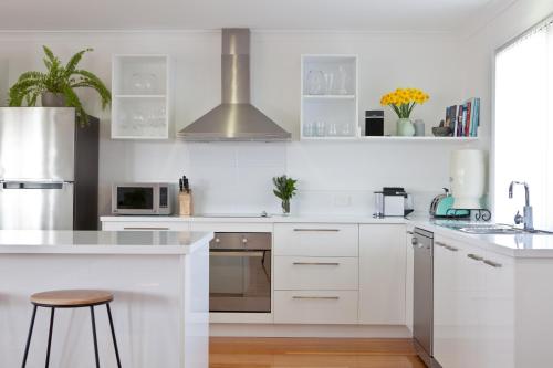 a white kitchen with white cabinets and a sink at Pearl Hawley Beach in Port Sorell