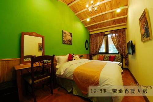 a green bedroom with a bed and a desk and a mirror at Hsitou Man Tuo Xiang Homestay in Lugu