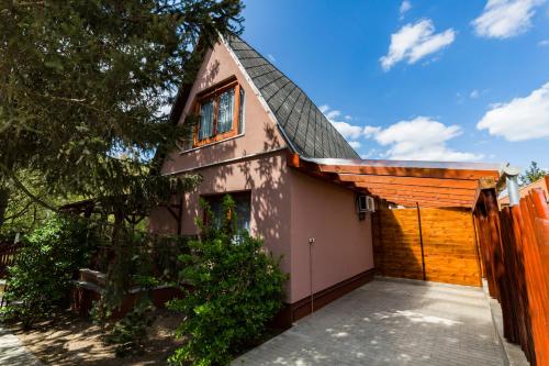 a pink house with a gambrel roof at Mineral apartman Smaragd in Nyíregyháza