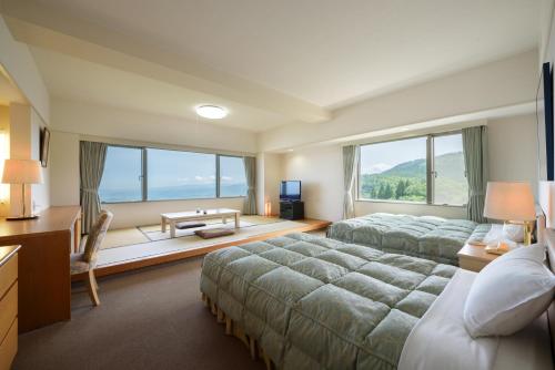 una camera d'albergo con due letti e una grande finestra di Aomori Winery Hotel a Ōwani