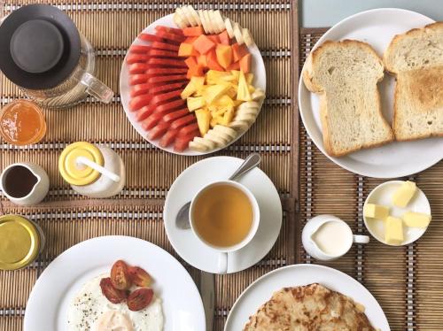 a table topped with plates of food and a cup of coffee at Khalid's Guest House in Galle