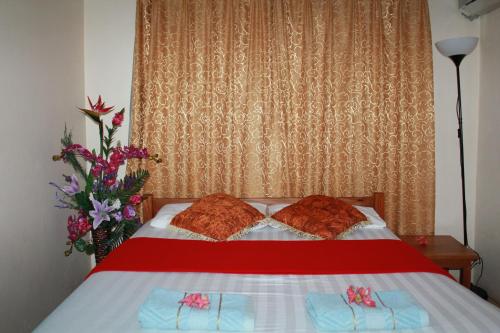 a bedroom with a bed with two pillows and a window at Pacific Paradise Motel in Port Vila