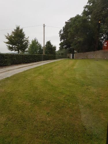 a grassy field next to a fence and a road at Moorepark West House in Fermoy
