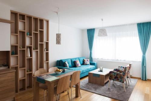 a living room with a blue couch and a table at Turistic Apartments Centar Sarajevo in Sarajevo