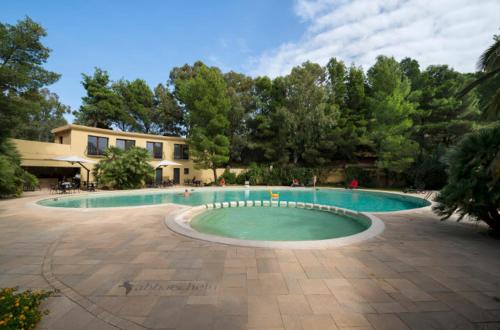 una gran piscina frente a un edificio en Abbaechelu en Santa Margherita di Pula