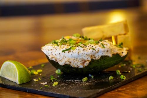 a egg in a avocado with a slice of lime at Old Town Boutique Hotel in Bucharest