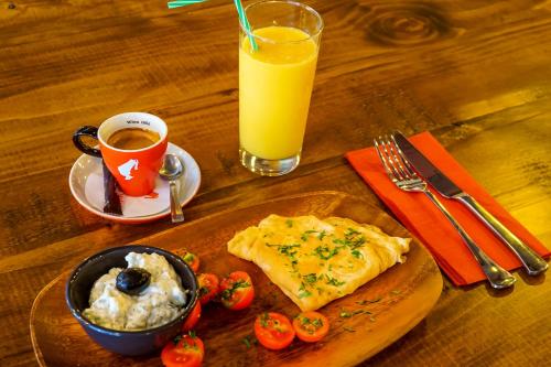 a wooden table with a plate of food and a cup of orange juice at Old Town Boutique Hotel in Bucharest