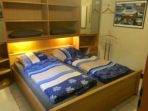 Una cama con mantas y almohadas azules y blancas. en Apartment Palmié, en Roth