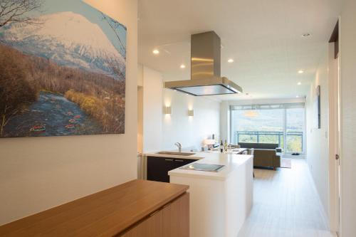 a kitchen with a painting of a mountain at Niseko Landmark View in Kutchan