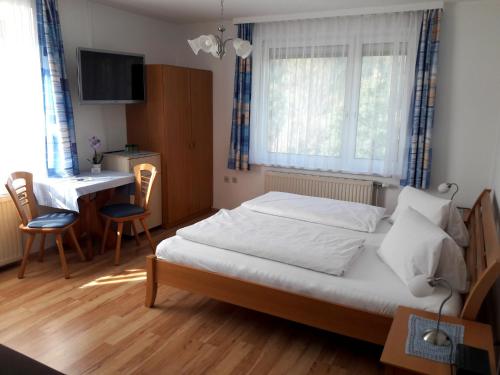 Schlafzimmer mit einem Bett, einem Tisch und Stühlen in der Unterkunft Gasthof-Pension Silvia in Haibach ob der Donau