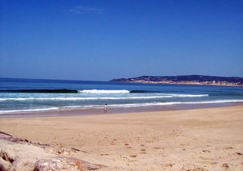 a person standing on a beach near the ocean at Parque De Campismo Orbitur Gala in Figueira da Foz