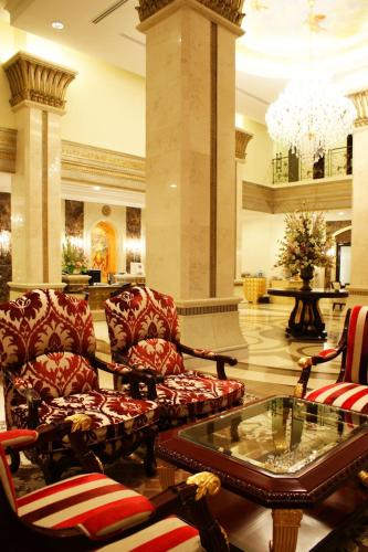 a lobby with chairs and a table and a chandelier at LK Residence in Pattaya Central