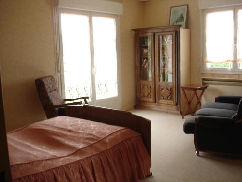 ein Schlafzimmer mit einem Bett, einem Sofa und Fenstern in der Unterkunft gite Loca in Provenchère