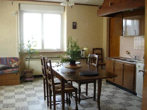 eine Küche mit einem Holztisch und Stühlen sowie einem Fenster in der Unterkunft gite Loca in Provenchère