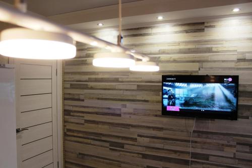 オレンブルクにあるАпартаменты в центре OrenRoom56の木製の壁にテレビが備わる部屋