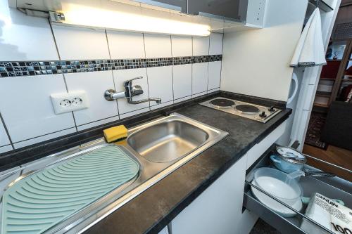 a kitchen sink with a stack of plates next to it at Lovely studio in Augsburg in Augsburg