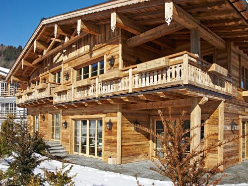 a large wooden house with a balcony on it at Chalet-F in Ofterschwang