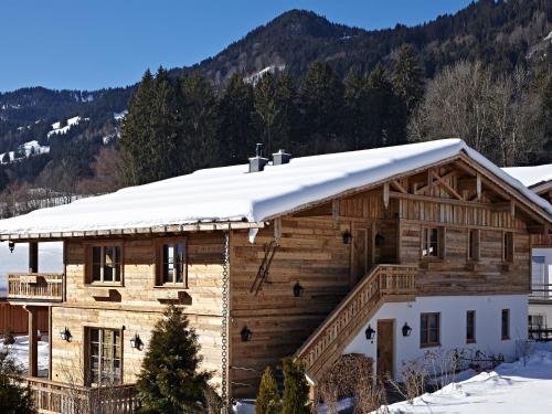 a log home with snow on the roof at Chalet-F in Ofterschwang