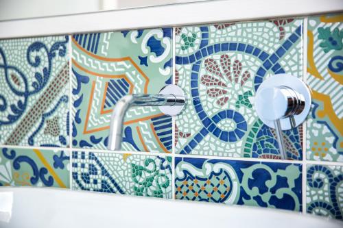 a bathroom with blue and white tiles on the wall at Uliwood in Caltanissetta