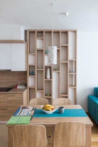 a dining room with a table with chairs and a book shelf at Turistic Apartments Centar Sarajevo in Sarajevo
