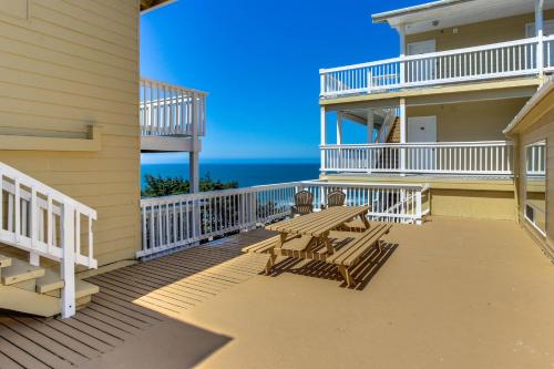 a deck with a picnic table and the ocean at Sandstone Point Hotel in Lincoln City
