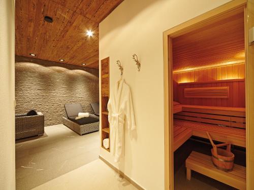um quarto com sauna e um quarto com sofá em Chalet-F em Ofterschwang