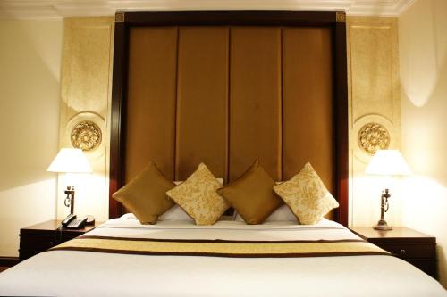 a bed with a large padded headboard in a room at LK Residence in Pattaya Central